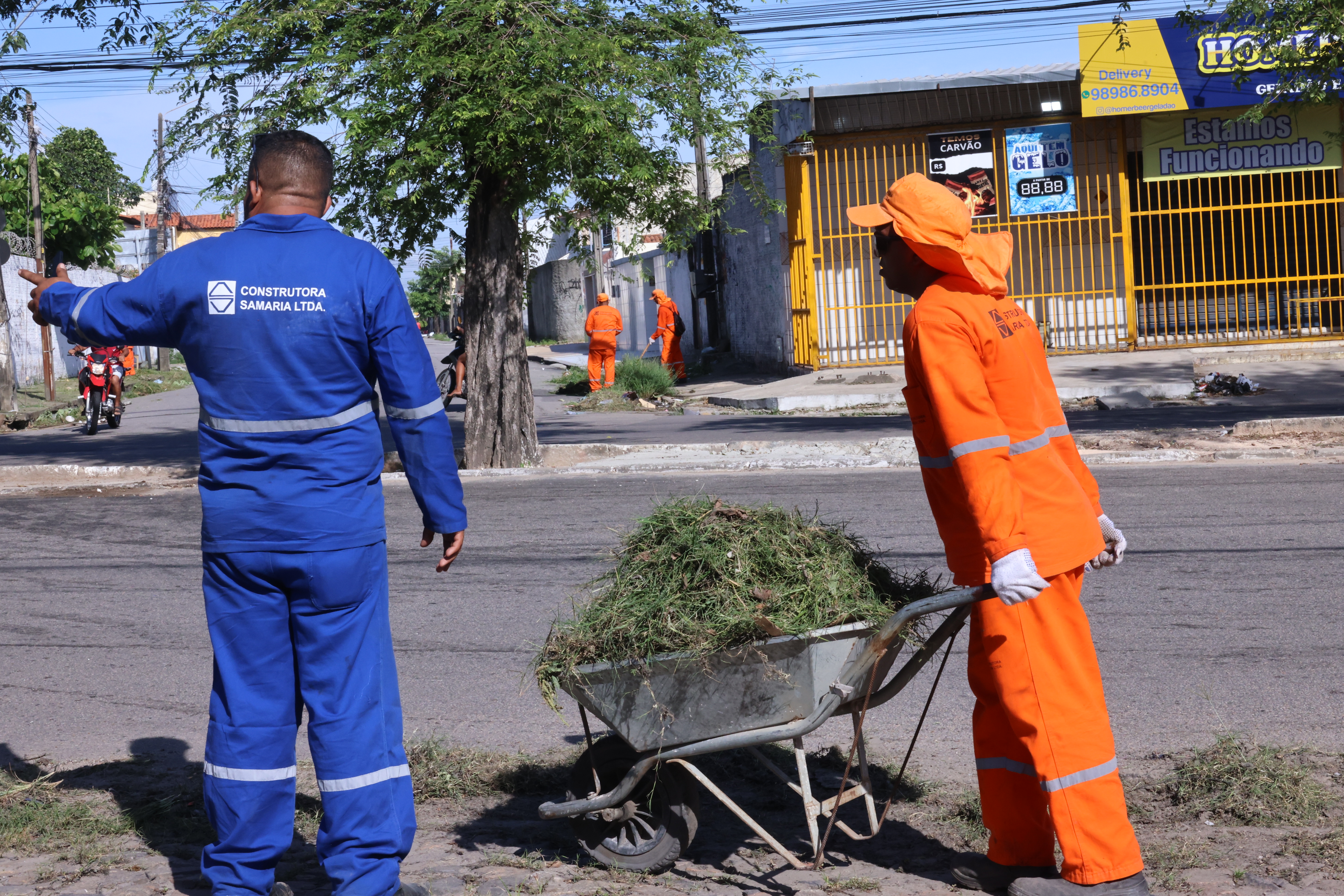 operário com um carrinho de mão levando o lixo recolhido